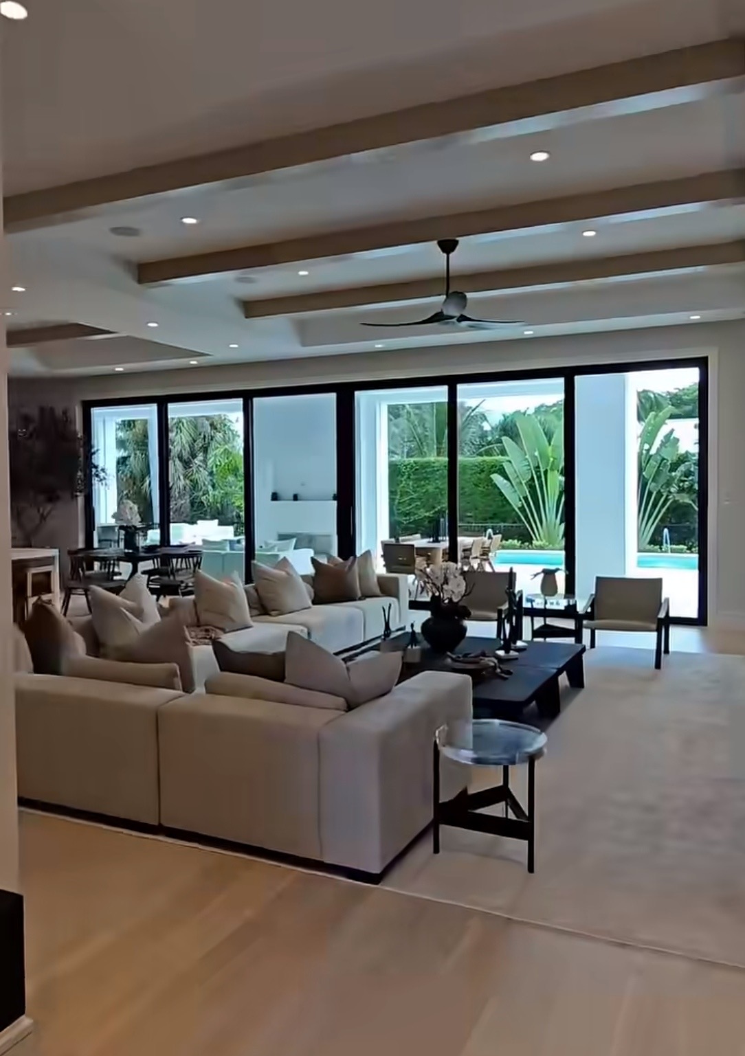 Sunlit minimalist living room with warm sand tones and oak chair